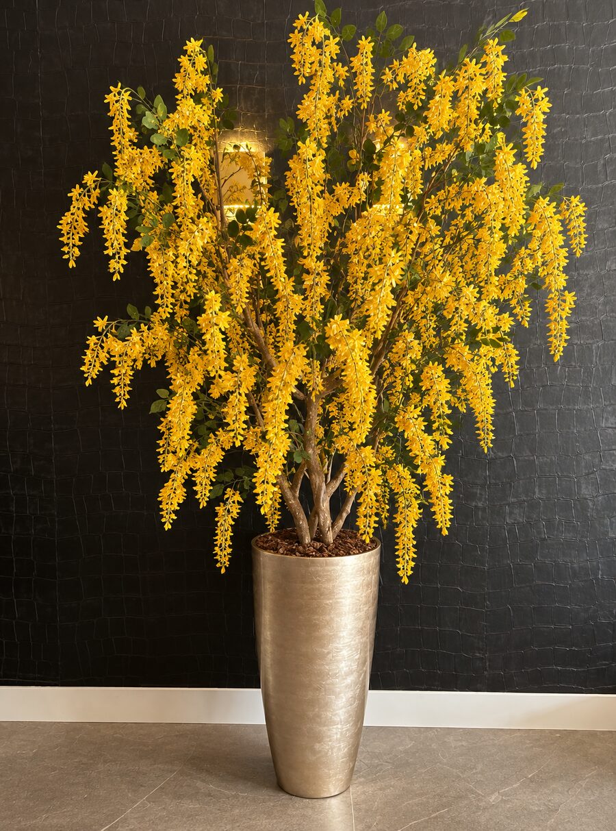 Botanical tree with yellow blossoms in a gold planter